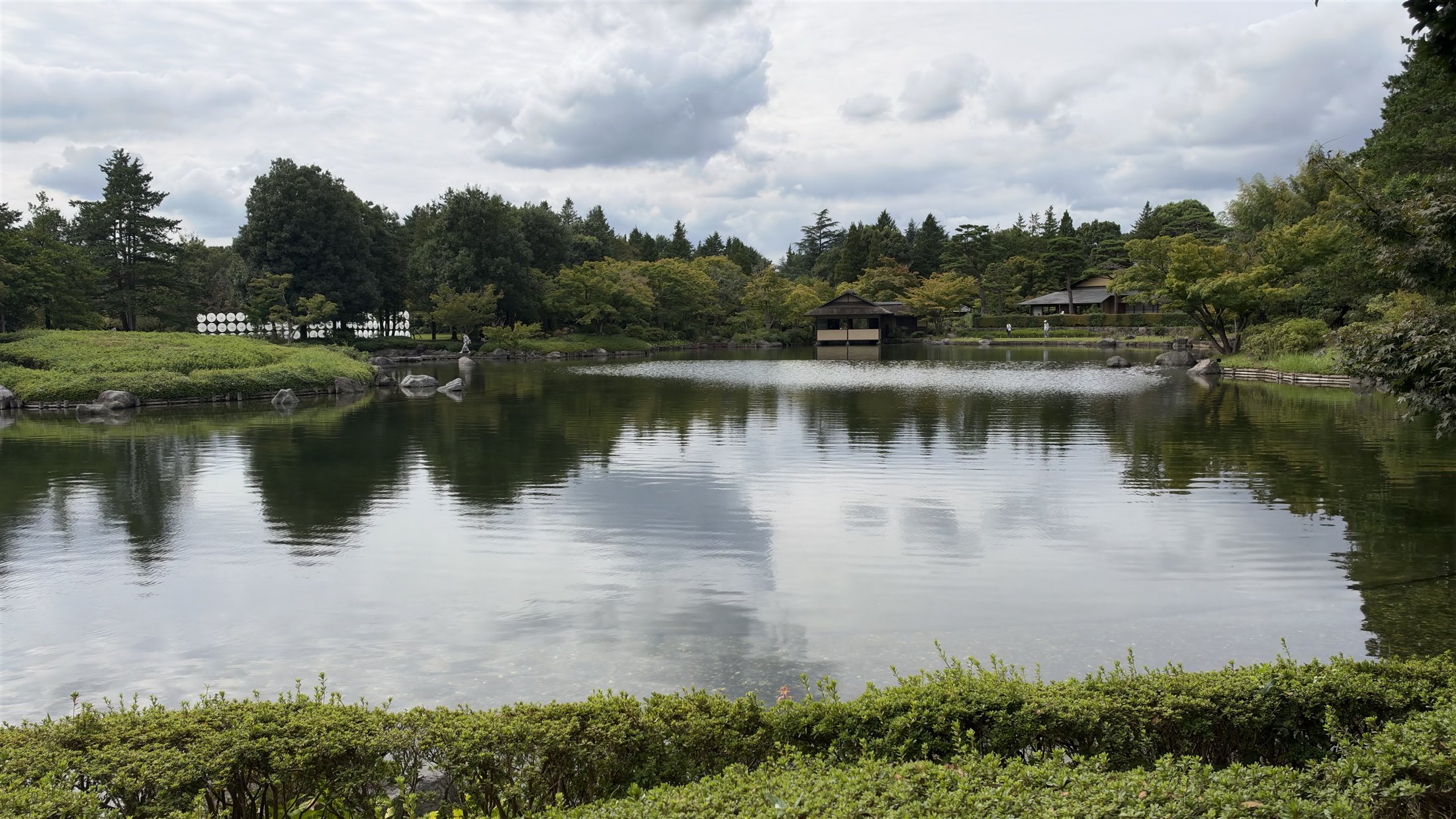 空と雲を反射する日本庭園の池の水面